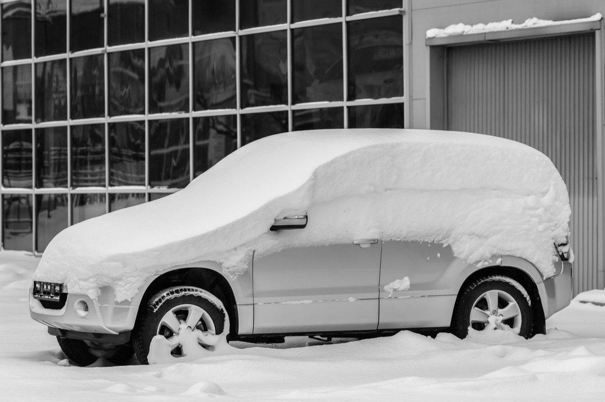 snow-covered car with fogged windows on icy road