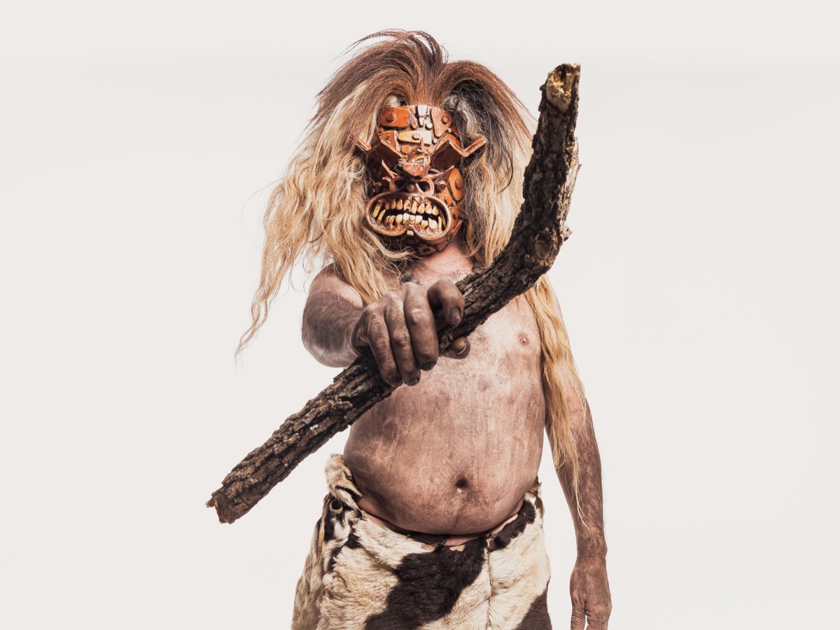 Ainu elder with traditional Ainu mask in forest setting